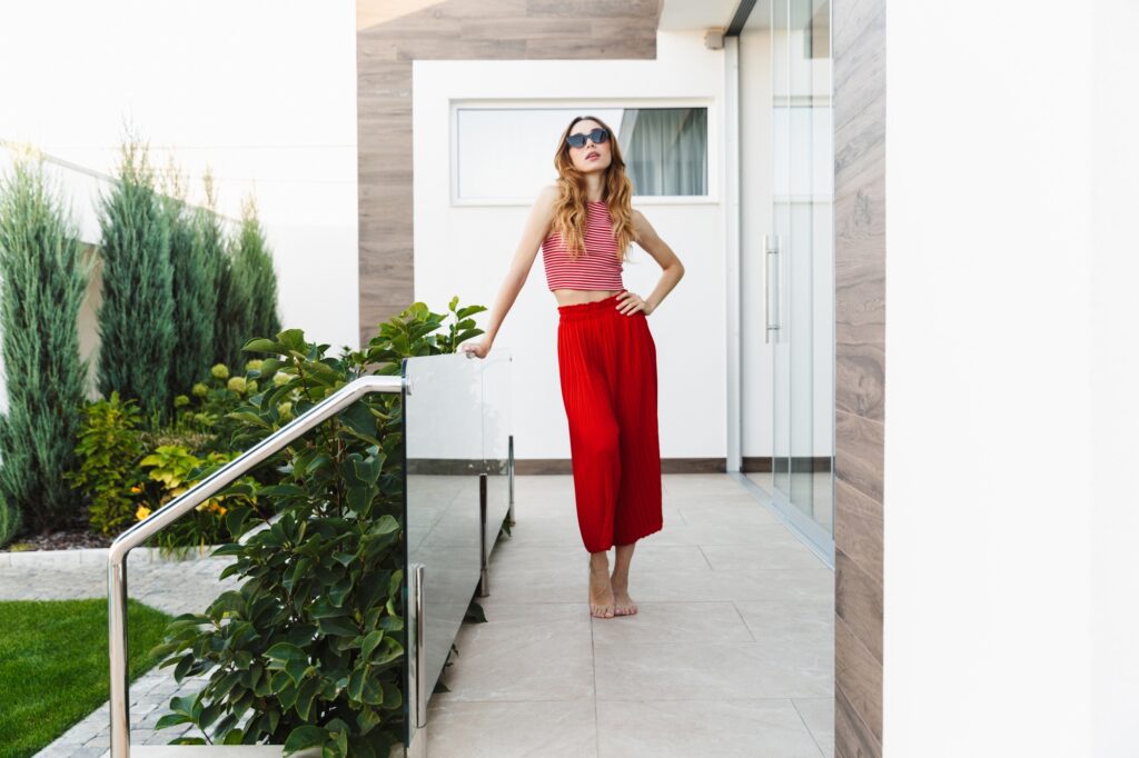 Beautiful young woman standing near hotel outdoors.