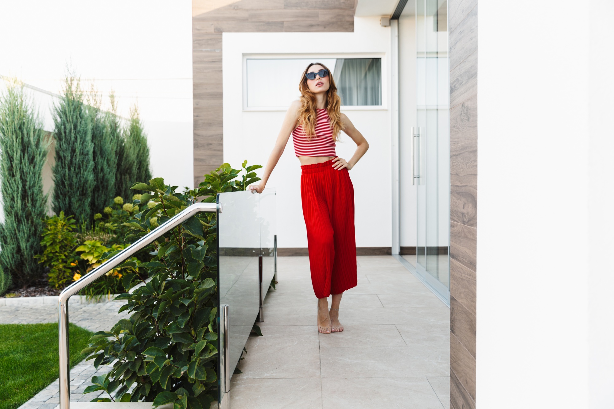 Beautiful young woman standing near hotel outdoors.
